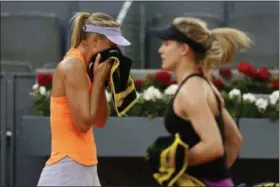  ?? FRANCISCO SECO — THE ASSOCIATED PRESS ?? Maria Sharapova from Russia, left, wipes the sweat from her face as Eugenie Bouchard from Canada walks past her during a Madrid Open tennis tournament match in Madrid, Spain, on Monday. Bouchard won 7-5, 2-6and 6-4.