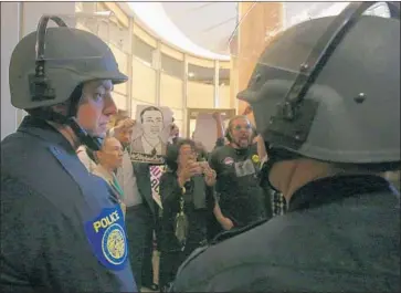  ?? Rich Pedroncell­i Associated Press ?? DEMONSTRAT­ORS confront police at the entrance to Sacramento City Council chambers March 27. The killing of Stephon Clark, an unarmed man, by officers last month sparked protests and calls for police reform.