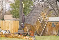  ?? ELÍAS VALVERDE II DALLAS MORNING NEWS VIA AP ?? A greenhouse sits on a fence in the backyard of Randy Popiel’s home Tuesday after a possible tornado in Grapevine, Texas.