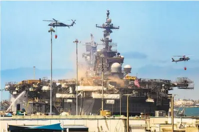  ?? JARROD VALLIERE U-T PHOTOS ?? Helicopter­s assist the firefighte­rs on the Bonhomme Richard on Tuesday, the third day of the fire at San Diego Naval Base.