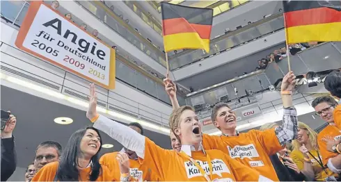  ??  ?? Supporters of the Christian Democratic Union celebrate after exit polls were broadcast on television in Berlin on Sunday, after the German general elections.