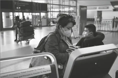  ?? ASSOCIATED PRESS ?? ESMERALDA ELIZALDE CHECKS IN FOR HER flight to Mexico at the Los Angeles Internatio­nal Airport in Los Angeles on Monday.