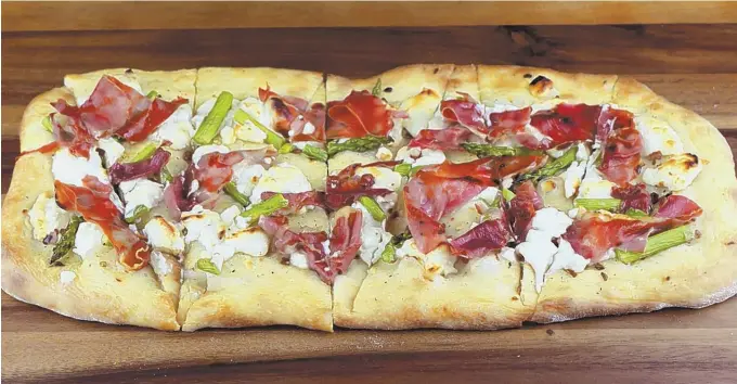  ?? HERALD PHOTO BY KERRY STANTON ?? YUMMY: Honey infused goat cheese adds a sweet and creamy touch to flatbread piled with prosciutto and asparagus.