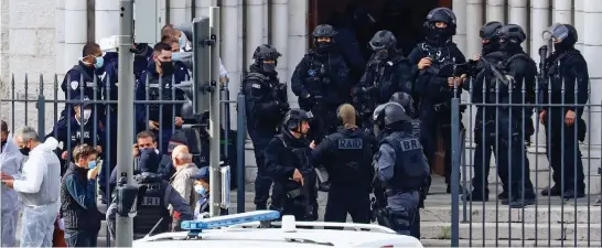  ??  ?? Aftermath: Armed police and investigat­ors outside Notre Dame basilica in Nice after the knifeman was captured yesterday