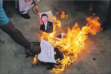  ?? Ajit Solanki Associated Press ?? PROTESTERS in Ahmedabad, India, burn items including a photograph of Chinese President Xi Jinping during a demonstrat­ion last month over deadly clashes along the disputed Himalayan border blamed on Beijing.