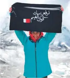  ?? Courtesy: Rasha Yousuf ?? Juwan Abdul Khaleq raises a banner with the Bahraini flag and a message that reads ‘I raise you above the clouds.’