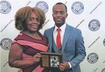  ??  ?? MOMENTO. El futbolista Derrick con su premio junto a su madre Erika Zapata.