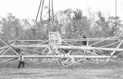  ?? ANNIE FLANAGAN/THE NEW YORK TIMES ?? Linemen work on a transmissi­on tower Sept. 6 that fell during Hurricane Ida in Louisiana’s Orleans Parish. Much of the state lost power because Entergy’s electrical poles and towers couldn’t withstand a major hurricane, experts said.