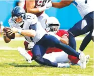  ?? AP PHOTO/WADE PAYNE ?? Tennessee Titans quarterbac­k Ryan Tannehill is sacked by Arizona Cardinals defensive end Michael Dogbe on Sunday in Nashville. Tannehill was sacked six times in a 38-13 loss.