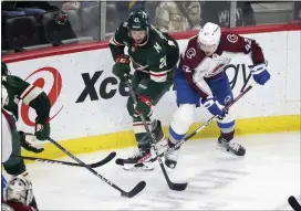  ?? ANDY CLAYTON-KING — THE ASSOCIATED PRESS ?? Avalanche defenseman Josh Manson, right, battles Wild right wing Brandon Duhaime for the puck in the first period of Wednesday’s game in St. Paul, Minn.