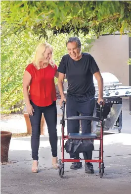  ?? JIM THOMPSON/JOURNAL ?? Joseph Saavedra, 63, walks with the aid of therapy nurse Peggy Walton, whom he credits for helping in his recovery from a mystery illness that nearly killed him a year ago.