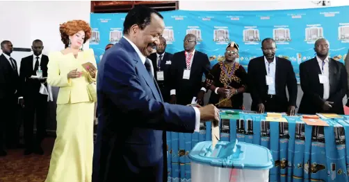  ?? | ZOHRA BENSEMRA | Reuters ?? CAMEROONIA­N President Paul Biya casts his ballot with his wife Chantal watching at a polling station during the presidenti­al election in Yaoundé last week.