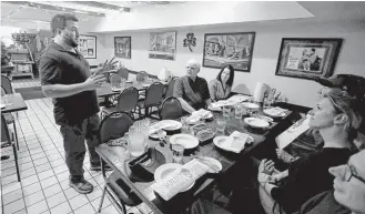  ?? Jeff Chiu / Associated Press ?? Avital Food Tours culinary guide Philip Hall, left, speaks to a group taking a tour at Sotto Mare restaurant in San Francisco. When labor costs go up at the restaurant­s, Avital’s costs rise too.