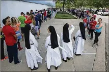  ?? MICHAEL CIAGLO/HOUSTON CHRONICLE VIA AP ?? Dominican Sisters of Mary Immaculate Province join a long line of people waiting to volunteer at NRG Center in Houston on Wednesday.