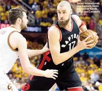  ??  ?? Jonas Valanciuna­s, des Raptors, tente de contrer Kevin Love, des Cavaliers