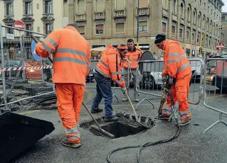  ??  ?? Gli operai al lavoro sul tombino di via Valfonda la cui rottura ha portato alla chiusura della strada nel pomeriggio di ieri A destra le macchine incolonnat­e in via della Scala