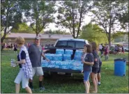  ?? BOB KEELER — MEDIANEWS GROUP ?? Tom, left, and Terri Moyer, right front, hand out bottles of water at the July 10 Moyer Indoor/Outdoor 5K.