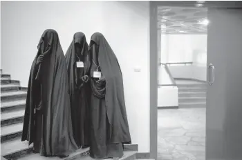  ?? FELIPE DANA/AP ?? Women stand inside an auditorium at Kabul University’s education center during a demonstrat­ion Sept. 11 in support of the Taliban in Afghanista­n’s capital city. The country’s public universiti­es remain closed.