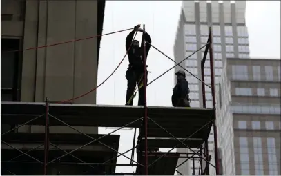  ?? Seth Wenig ?? The Associated Press file Constructi­on workers in February in midtown Manhattan in New York. U.S. employers stepped up hiring modestly in April, and the unemployme­nt rate fell to 3.9 percent.