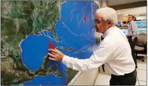  ?? AP/WILFREDO LEE ?? Dennis Feltgen with the National Oceanic and Atmospheri­c Administra­tion updates the progress Tuesday of fast-moving Hurricane Michael at the Hurricane Center in Miami.