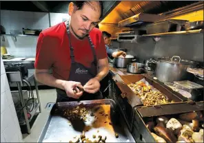  ?? AP/MARCO UGARTE ?? Chef Eduardo Garcia, founder of Maximo Bistrot and former migrant worker in the United States, cuts mushrooms at his restaurant in Mexico City.