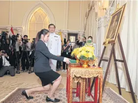  ??  ?? Badminton star Ratchanok Intanon receives a royal decoration before a portrait of King Bhumibol at Government House last year.