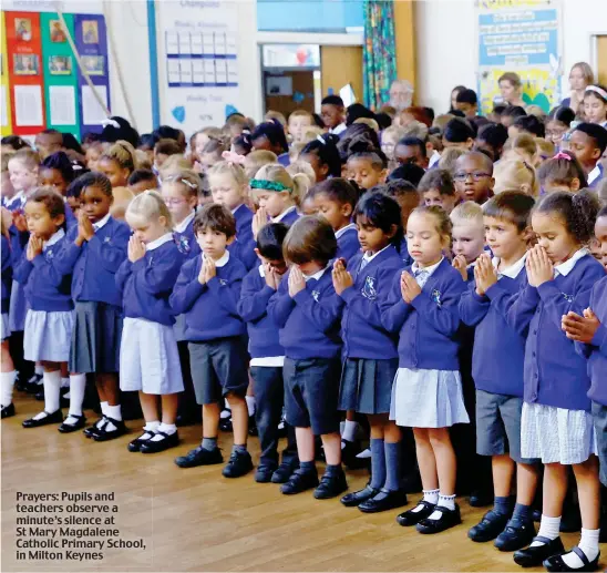  ?? ?? Prayers: Pupils and teachers observe a minute’s silence at St Mary Magdalene Catholic Primary School, in Milton Keynes
