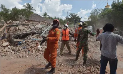  ?? Photograph: Adek Berry/AFP/Getty Images ?? Indonesian search and rescue personnel in Lombok after a 6.2-magnitude aftershock hit on Thursday.