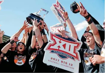  ?? [PHOTOS BY SARAH PHIPPS, THE OKLAHOMAN] ?? Oklahoma State players hold a Big 12 championsh­ip sign after winning the conference tournament on Sunday at Chickasaw Bricktown Ballpark. The Cowboys beat Texas, 6-5.