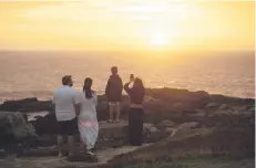  ?? ?? Tourists take snapshots at sunset in José Ignacio beach, Maldonado department, Uruguay.