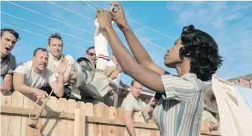  ??  ?? Director George Clooney works on the set of Suburbicon, above, while Karimah Westbrook, below, plays Mrs. Mayers in a scene from the new movie.