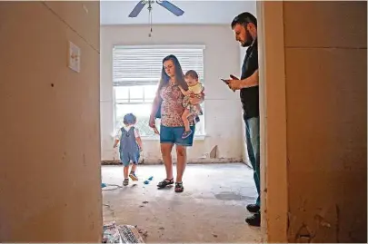  ?? Mark Mulligan photos / Houston Chronicle ?? Richard and Ashley Freilich and their children Cole, 3, and Rebecca, 15 months, evacuated their apartment during last week’s flood. When Richard returned to collect some of their possession­s, cleaning crews had already thrown them out.