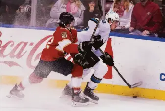  ?? Marta Lavandier / Associated Press ?? Panthers defenseman Brandon Montour (62) and Sharks center Jasper Weatherby fight for the puck. The Sharks took a 4-2 lead in the third period but the Panthers rallied to force overtime.