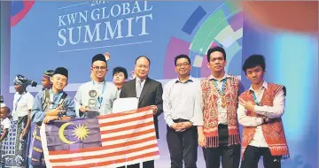  ??  ?? (From left) Michael and Saffuan in a group photo with officials from the Malaysian Embassy in Tokyo and Panasonic, as well as the team members from SMK Batu Lintang.