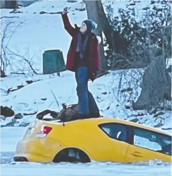  ?? @MAMMAMITCH/TWITTER ?? A woman takes a selfie on top of her car as it sinks through the Rideau River ice.