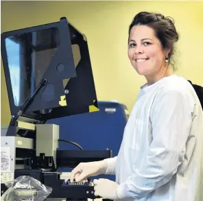  ?? PHOTO: PETER MCINTOSH ?? Extra capacity . . . Southern Community Laboratori­es molecular pathology department head Jenny Grant with an Australian machine which tests for Covid19.