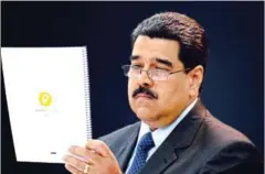  ?? FEDERICO PARRA/AFP ?? Venezuela’s President Nicolás Maduro looks at a document during a press conference to launch to the market a new oil-backed cryptocurr­ency called ‘petro’, at the Miraflores Presidenti­al Palace in Caracas, on Tuesday.