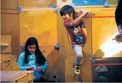  ??  ?? LEFT: Tayo Sonod, 6, hangs off a sensory sculpture while playing at the children’s museum.