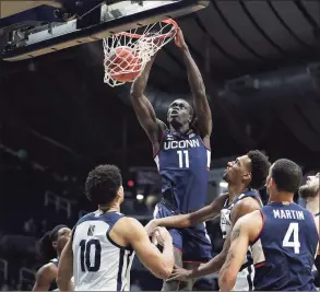  ?? Jenna Watson / Associated Press ?? UConn’s Akok Akok dunks against Butler on Saturday in Indianapol­is, his first action since suffering an Achilles’ tendon injury last year.