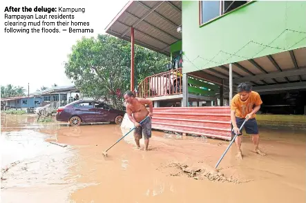  ?? ?? After the deluge: Kampung rampayan Laut residents clearing mud from their homes following the floods. — Bernama