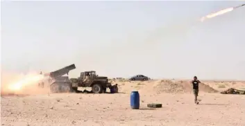  ?? — AFP ?? Syrian government forces fire a multiple rocket launcher from a position in Kobajjep area, on the southweste­rn outskirts of Deir Ezzor during the ongoing battle against IS.