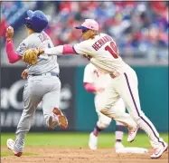  ?? Derik Hamilton / Associated Press ?? Cesar Hernandez, right, reaches to tag out New York’s Wilmer Flores for a double play during the sixth inning on Sunday.