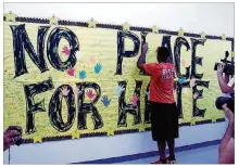  ?? PFLUGERVIL­LE PFLAG 2012 ?? In2012,then-University­ofT exas football player Alex Okafor signs
a “No Placef or H ate”ba n nerat Wieland Elementary in Pflugervil­le shortly before an anti-bullying program there. Okafor is a Pflugervil­le High School alumnus.