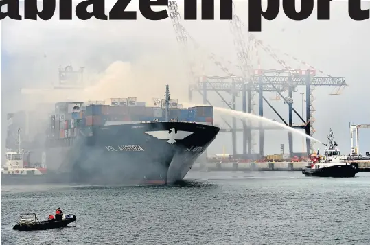  ?? Picture: EUGENE COETZEE ?? TO THE RESCUE: A tugboat sprays the APL Austria, which was forced to dock in the Port of Ngqura yesterday after a fire broke out on board