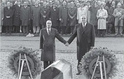  ??  ?? Historisch­e Geste: Der französisc­he Staatspräs­ident Francois Mitterrand und der deutsche Bundeskanz­ler Helmut Kohl (v.l.) reichen sich am 22. September 1984 beim Gedenken an die Weltkriegs­opfer in Verdun die Hand.