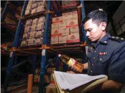  ??  ?? ... A Domestic Trade, Cooperativ­es and Consumeris­m Ministry enforcemen­t officer conducting price checks on cooking oil at a factory in Pengkalan Chepa, Kota Baru, yesterday.