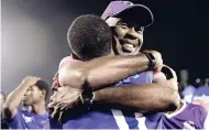  ?? GLADSTONE TAYLOR/PHOTOGRAPH­ER ?? Kingston College coach Ludlow Bernard hugs captain Casseam Priestly after KC’s 3-2 win over St George’s College in the ISSA/Digicel Manning Cup final at the National Stadium last Friday.