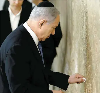  ??  ?? Pour sa principale apparition publique, le PM Benjamin Netanyahou s’est rendu au mur des Lamentatio­ns afin de placer un voeu en papier entre les pierres sacrées.