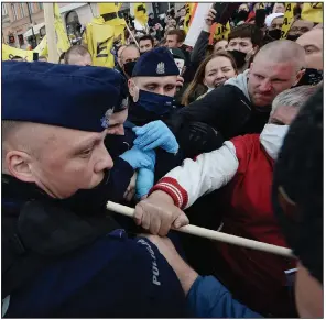  ?? (AP/Czarek Sokolowski) ?? Police clash with business owners and other protesters demanding an end to economic restrictio­ns Saturday in Warsaw, Poland. Dozens of people were detained, including a senator, as police used tear gas on demonstrat­ors. More photos at arkansason­line.com/517virus/.