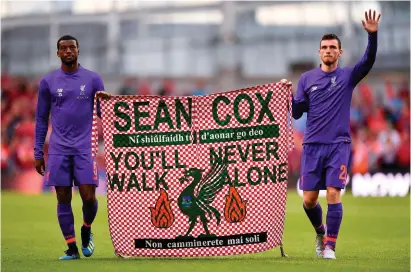  ?? SEB DALY/SPORTSFILE ?? Georginio Wijnaldum and Andy Robertson hold a banner showing Liverpool’s support for supporter Sean Cox after Saturday’s match against Napoli at the Aviva Stadium